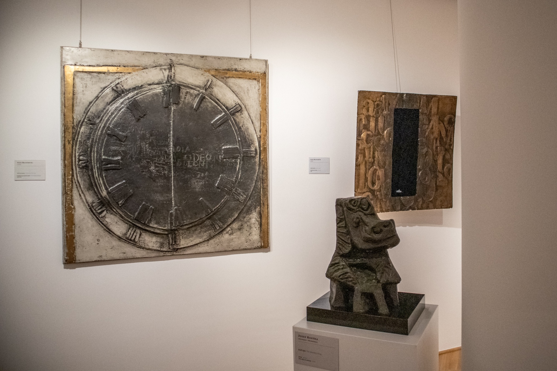 Na stene zľava: Alex Mlynarčík, Keď čas zomrie, 1963-64, kombinovaná technika na sololite; Alex Mlynarčík, Zlatá kaplnka, 1965, kombinovaná technika. Socha v popredí: Jozef Kostka, Kráľ opíc, sedemdesiate roky 20. storočia, bronz  (foto: KUNSTARTUM)