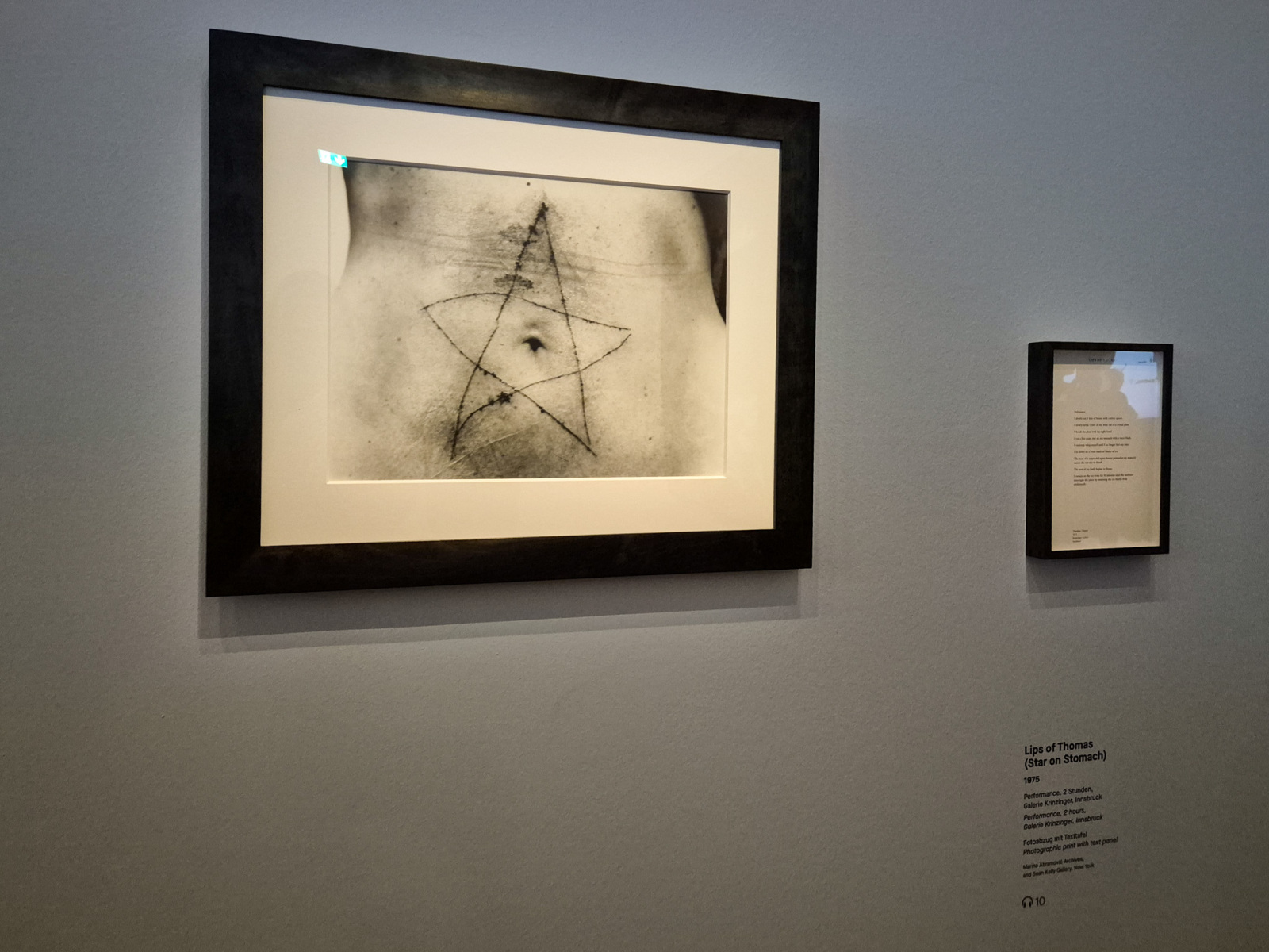Marina Abramović: Lips of Thomas (Star on Stomach), 1975, 2 hodinová performance, Galerie Krinzinger, Innsbruck; fotografický print  s textovým panelom. (foto: KUNSTARTUM)