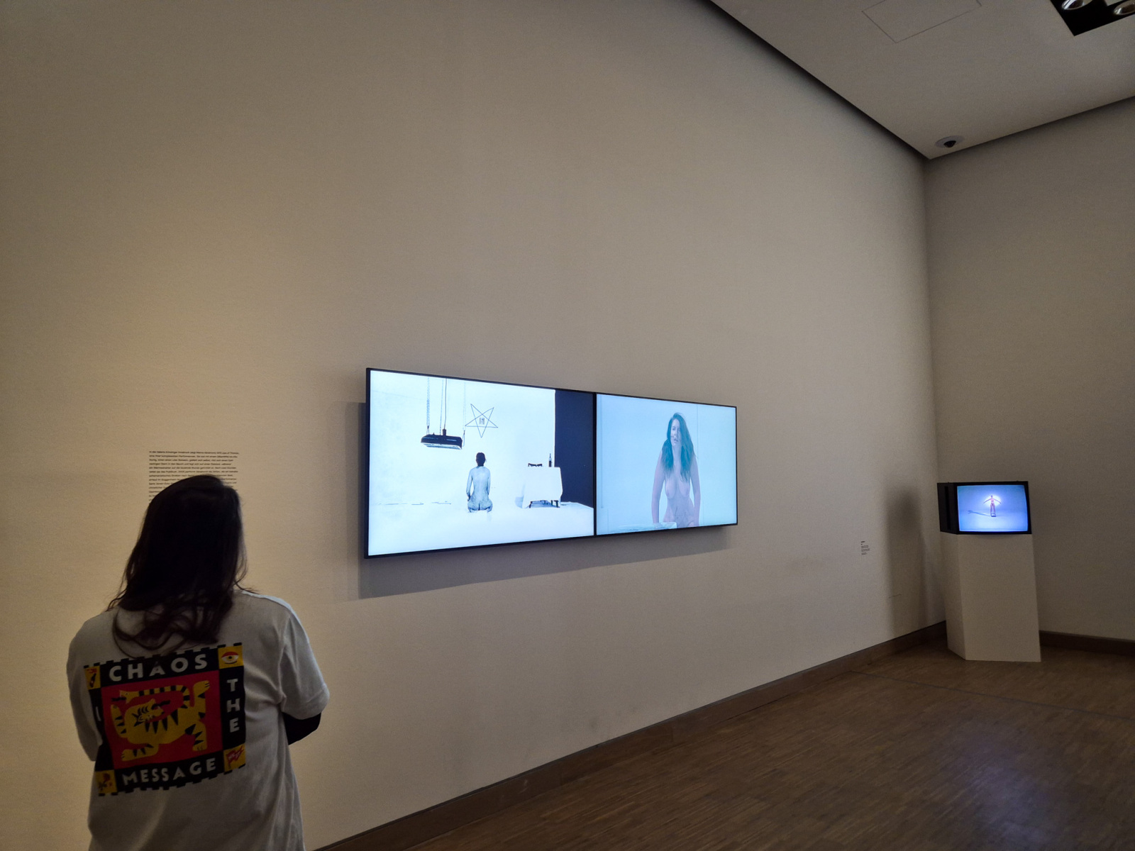 Na obrazovkách na stene – vľavo: Marina Abramović: Lips of Thomas, 1975, 2 hodinová performance, Galerie Krinzinger, Innsbruck; digitálna prezentácia bez zvuku, 1 hodina, 36 minút, 14 sekúnd. Vedľa vpravo: Marina Abramović: Lips of Thomas (Star on Stomach), 2005, 7 hodinová performance, Solomon R. Guggenheim Museum, New York; farebné video so zvukom, 1 hodina a 36 minút. (foto: KUNSTARTUM)