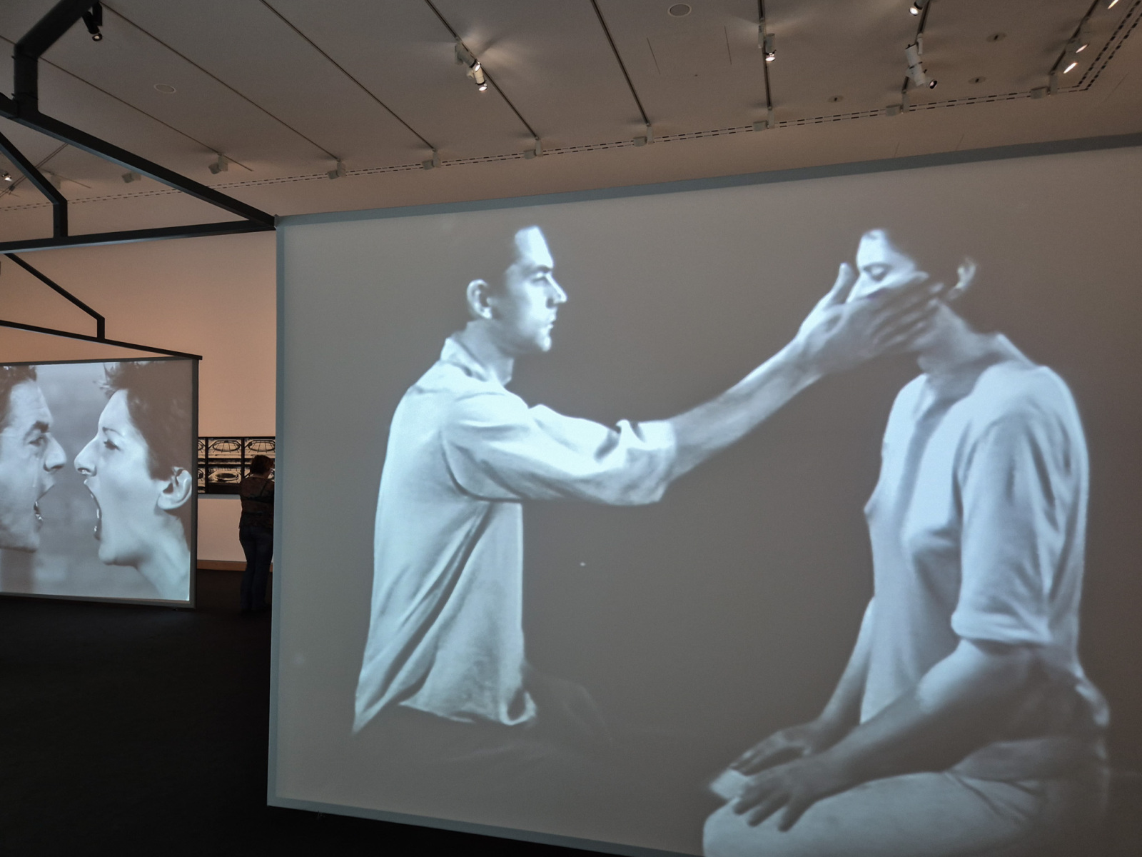 Záznam z performance na plátne v popredí vpravo: Ulay/Marina Abramović: Light Dark, 1978, performance, 8 minút a 15 sekúnd, Amsterdam; 16mm čiernobiely film transformovaný na digitálne video so zvukom, 8 minút a 15 sekúnd.  Záznam z performance na plátne v pozadí vľavo: Ulay/Marina Abramović: AAA – AAA, 1978, 15 minútová performance, RTB Studio, Liège; čiernobiele video so zvukom, 12 minút a 58 sekúnd. (foto: KUNSTARTUM)