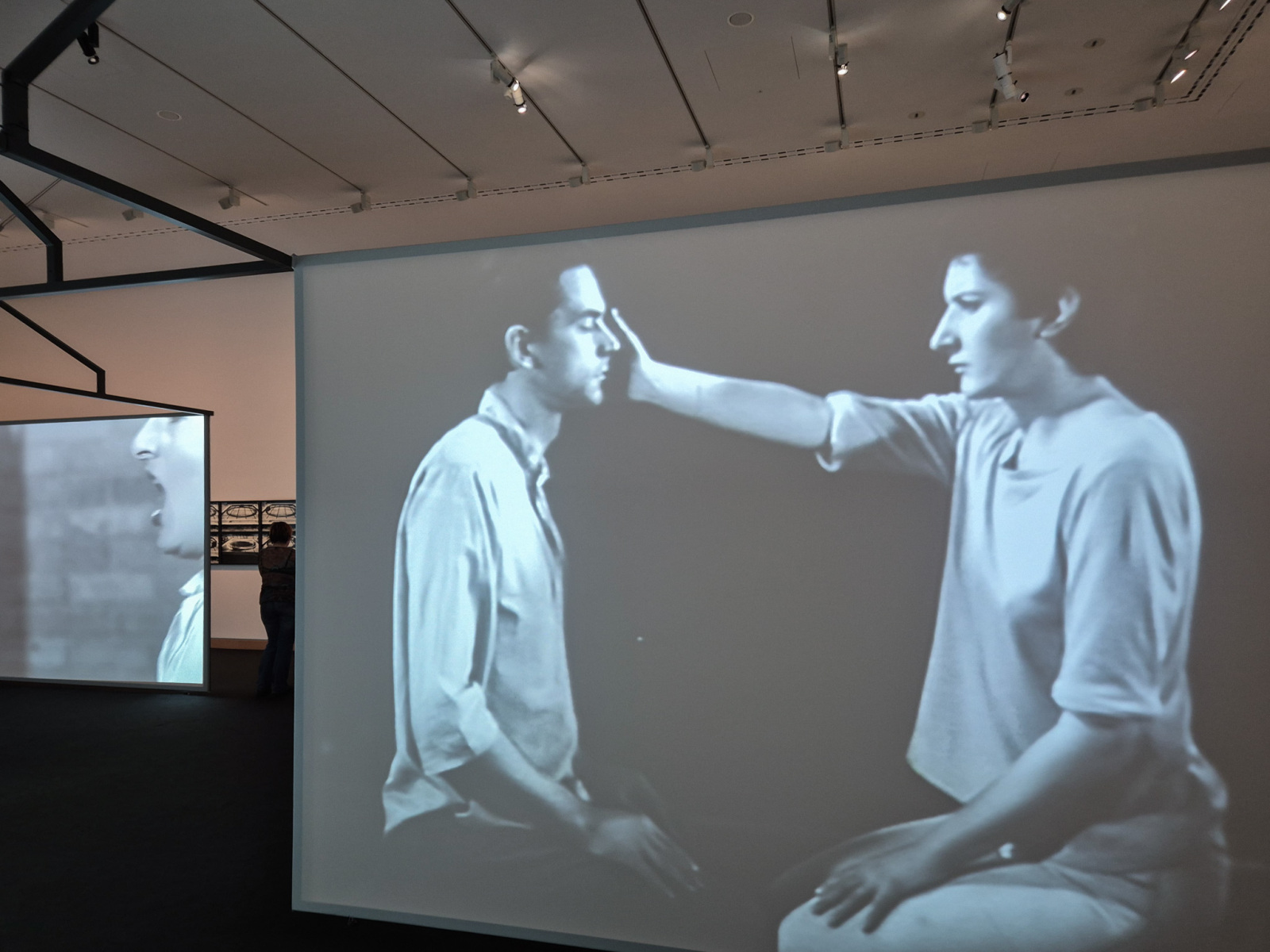 Záznam z performance na plátne v popredí vpravo: Ulay/Marina Abramović: Light Dark, 1978, performance, 8 minút a 15 sekúnd, Amsterdam; 16mm čiernobiely film transformovaný na digitálne video so zvukom, 8 minút a 15 sekúnd.  Záznam z performance na plátne v pozadí vľavo: Ulay/Marina Abramović: AAA – AAA, 1978, 15 minútová performance, RTB Studio, Liège; čiernobiele video so zvukom, 12 minút a 58 sekúnd. (foto: KUNSTARTUM)